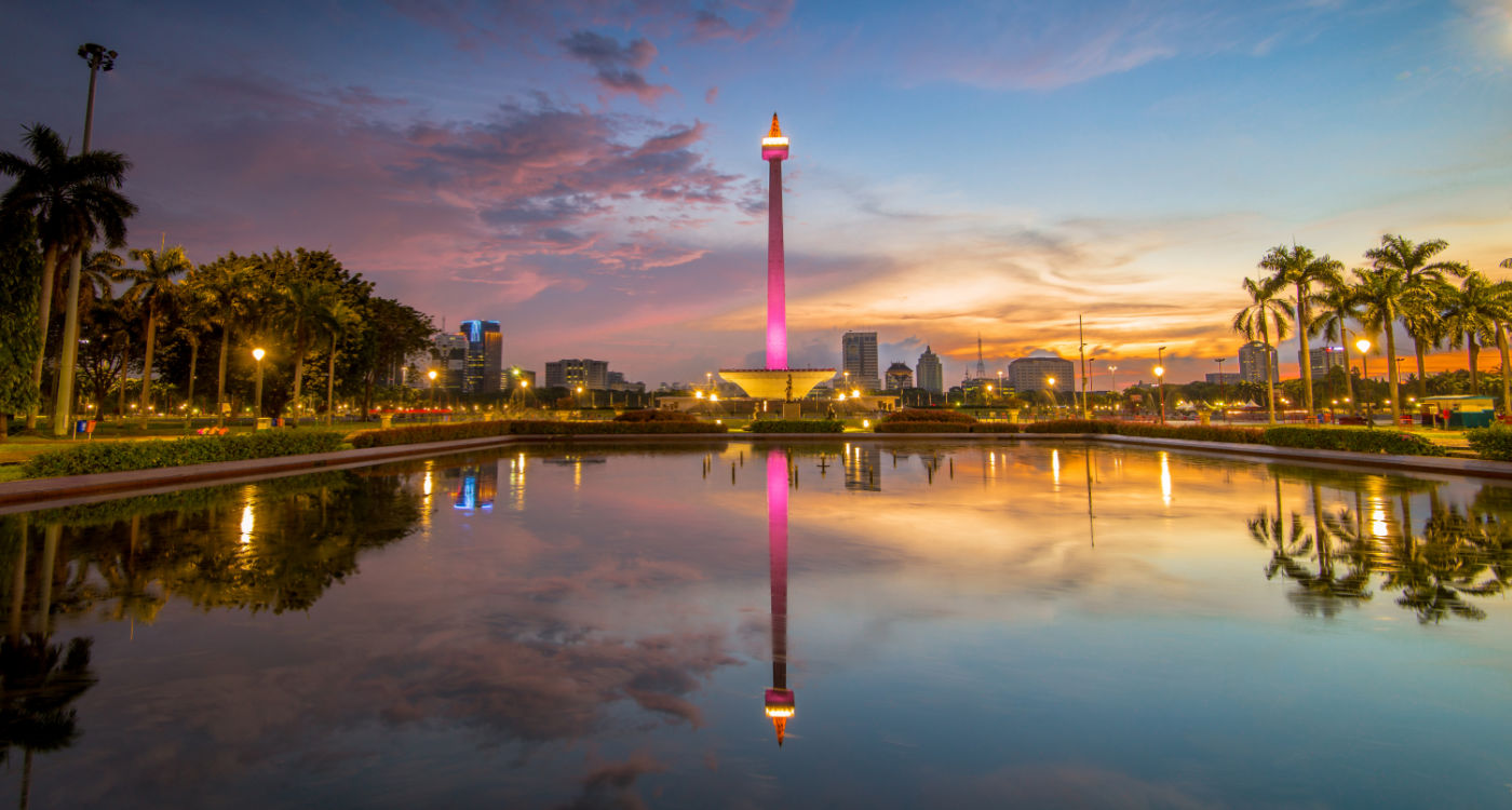 The National Monument, known as MONAS, a tall tower lit up in pink