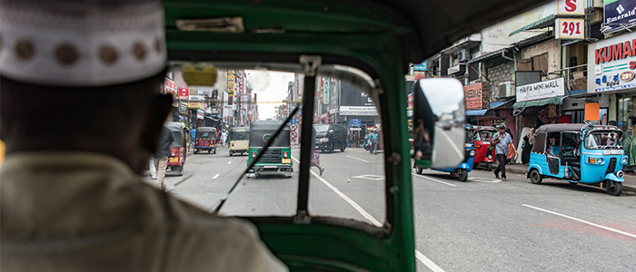 Man driving a green rickshaw in Colombo, Sri Lanka