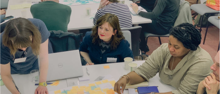 Image of four people around a table participating in a workshop.