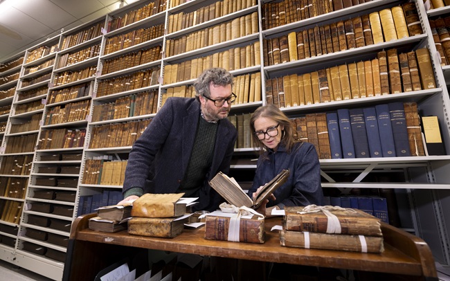 Professor Adrian Streete and Siobhán Convery, Director, Library Collections, look at a dictionary from the personal library of Zachary Boyd. Credit Martin Shields. Professor Adrian Streeteand and Siobhán Convery, Director, Library Collections, look at a dictionary from the personal library of Zachary Boyd. Credit Martin Shields.