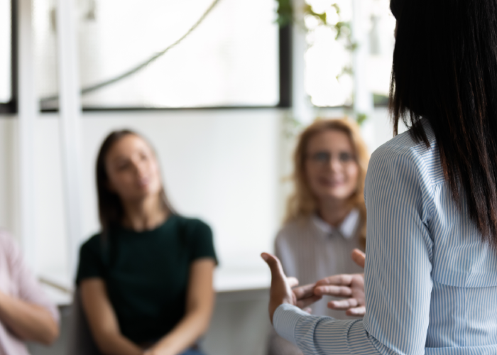 Rear back view female talking in a group setting