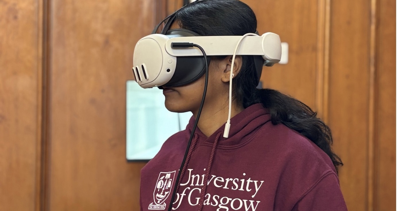 Student wearing a virtual reality headset and University of Glasgow hoodie