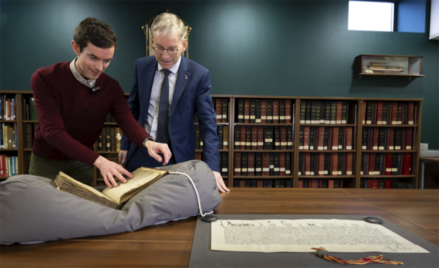 Professor Andy Schofield, University Principal and Vice Chancellor in the archives with archivist Michael Gallagher and a copy of the Papal Bull dated 1490. Also pictured is a 2001 copy of the Papal Bull