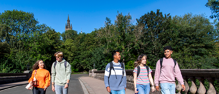 Students walking in the park with main building in the background