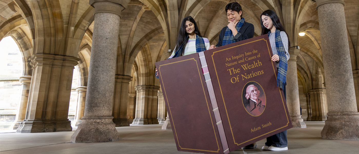 students with oversized Wealth of Nations book