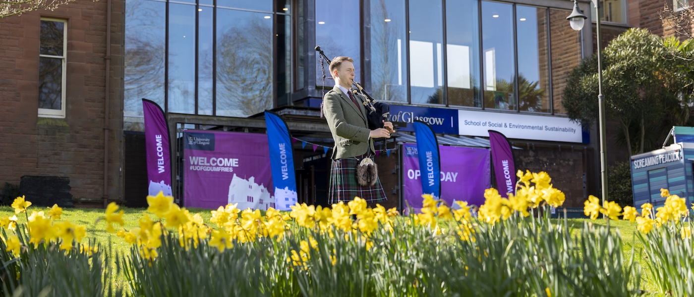 Piper playing at the front of the Rutherford McCowen Building at an Dumfries Campus Open Day