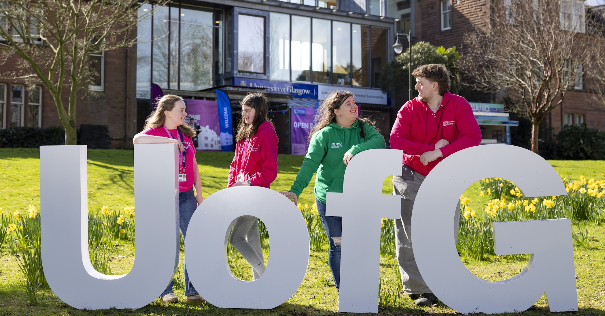 Four Dumfries Students Standing in Front of Large UofG Letters