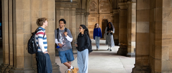 Group of students talking and walking in the cloisters