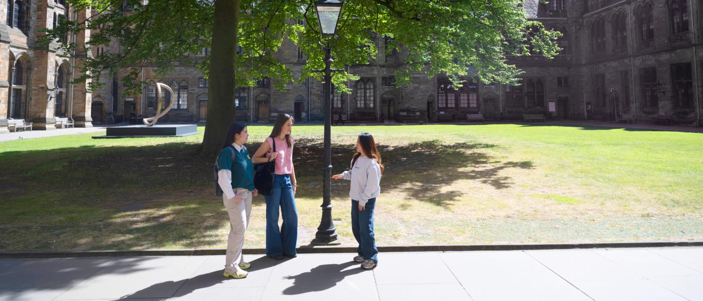 3 students beside lamp post in guads