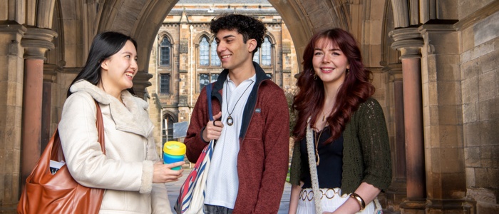 3 students on campus under an arch