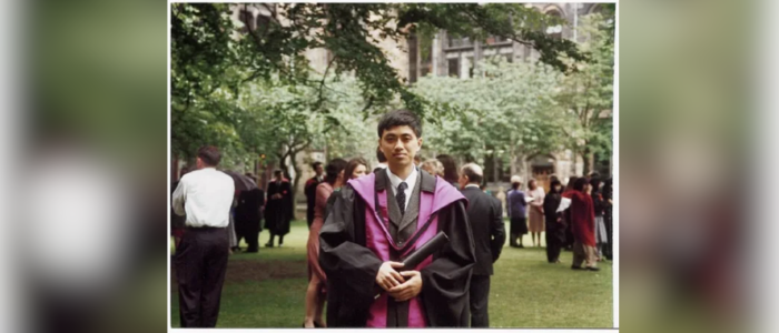 A photo of Dr Yi Yang in graduation robes at the University of Glasgow