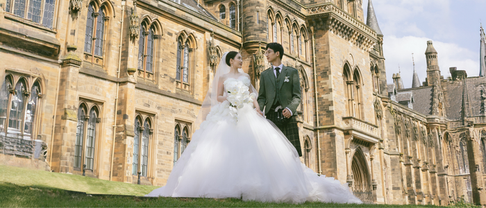 A photo of a couple on their wedding day in front of the Gilbert Scott Tower