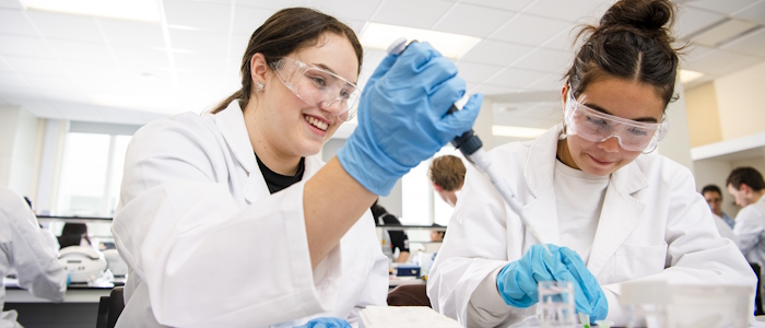 two students working with lab equipment