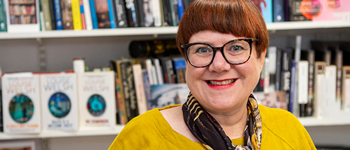 Professor Louise Welsh in front of her bookcase