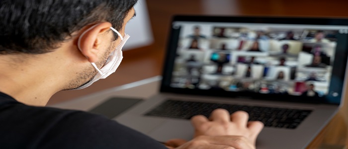 Man in mask using a laptop