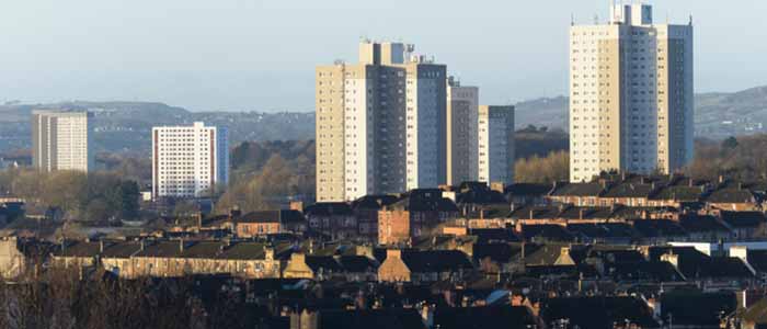Cityscape view over the west of Glasgow city and suburbs wirth houses, tower blocks, church spires, office buildings, and hills beyond the city. Source: Image credit: jph9362 | iStockphoto  https://www.istockphoto.com/photo/glasgow-cityscape-gm533699282-94539515 